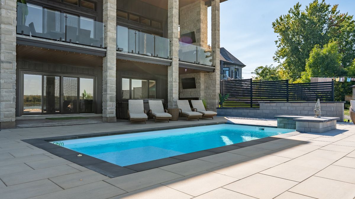 Daytime view of poolside patio and backyard landscaping