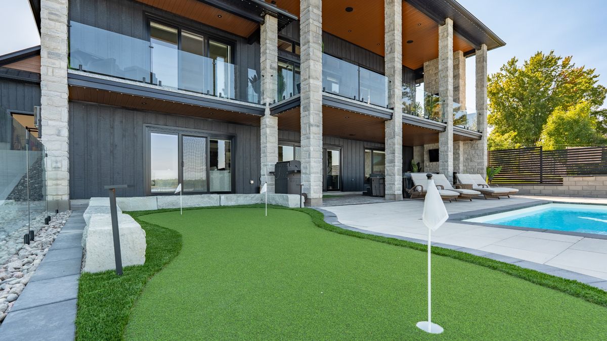 Synthetic turf putting green beside the pool